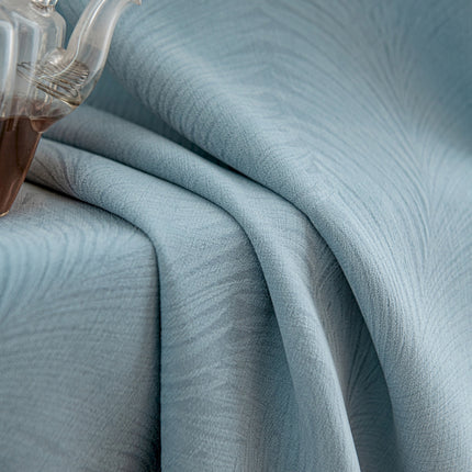 a bed with a blue bedspread and a teapot on top of it