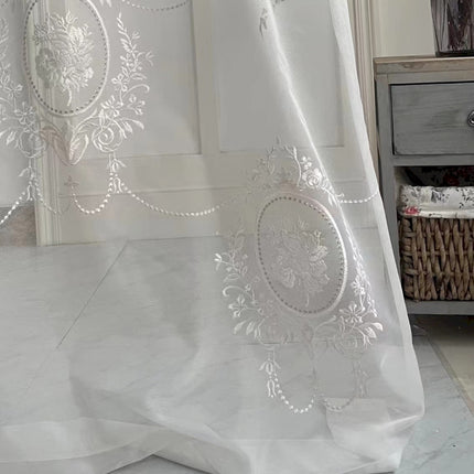 a white curtain with a design on it