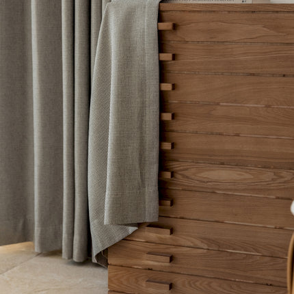 a close up of a bed with a wooden headboard