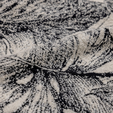 a black and white rug with a leaf pattern
