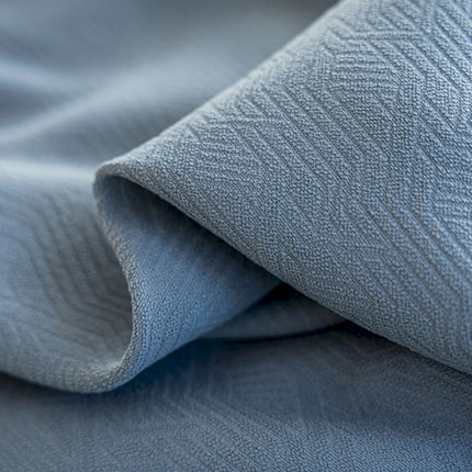 a close up of a bed with a blue comforter