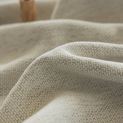 a close up of a cloth with a wooden object in the background