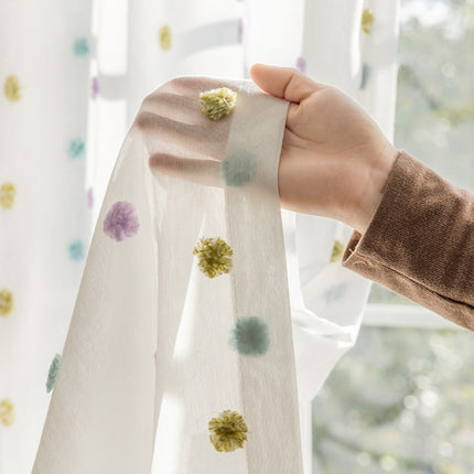 a person holding a curtain with a flower on it