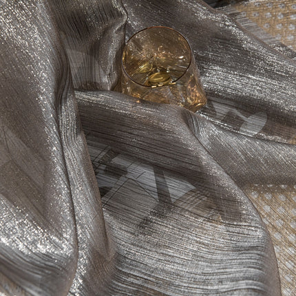 a glass sitting on top of a silver cloth