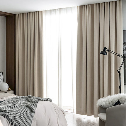 a bed room with a neatly made bed and a large window