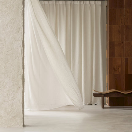 a room with a white curtain and a chair