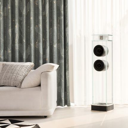 a living room with a white couch and speakers