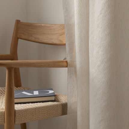 a book sitting on a chair next to a window