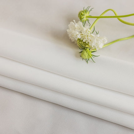 a close up of a white sheet with flowers on it