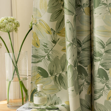 a vase of flowers sitting on a table next to a curtain