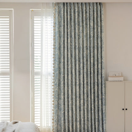 a bedroom with a bed and a window covered in curtains