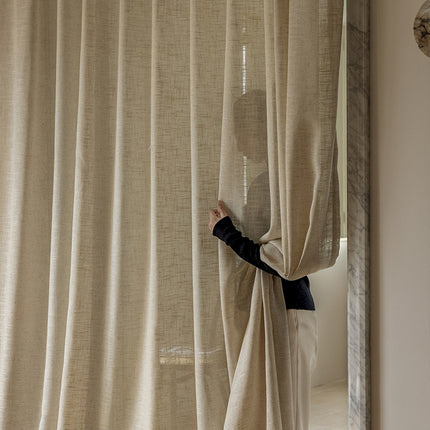 a person standing behind a curtain in a room