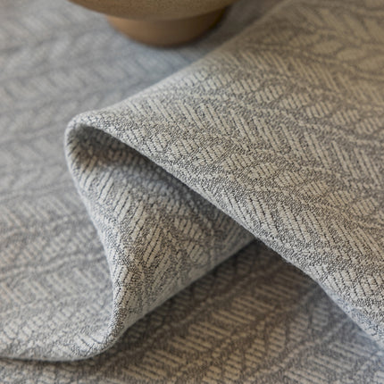 a close up of a cloth with a bowl in the background