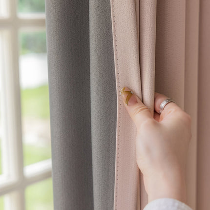 a woman's hand holding a curtain with a ring on it