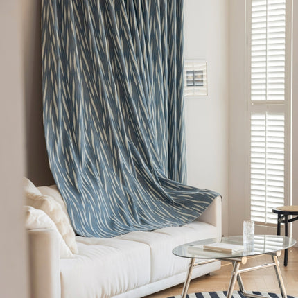 a living room with a white couch and a blue curtain