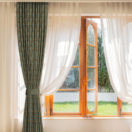 a window with a curtain and a chair in front of it