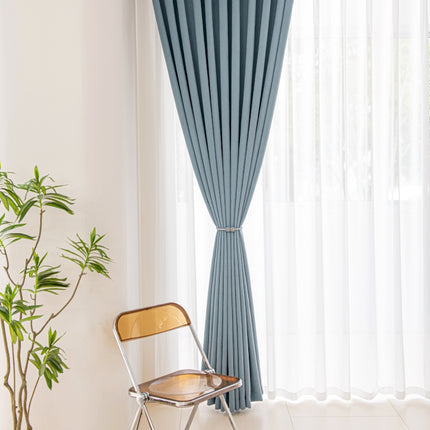 a chair sitting in front of a window next to a potted plant