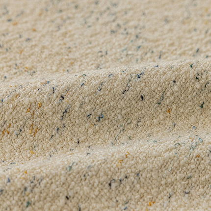 a close up of a white blanket with blue and yellow speckles