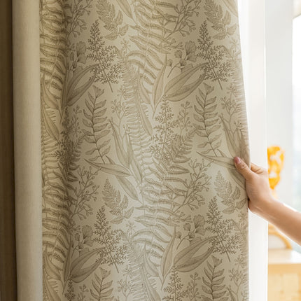 a person holding a curtain with a plant pattern on it