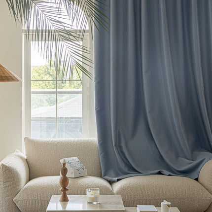 a living room with a white couch and a blue curtain