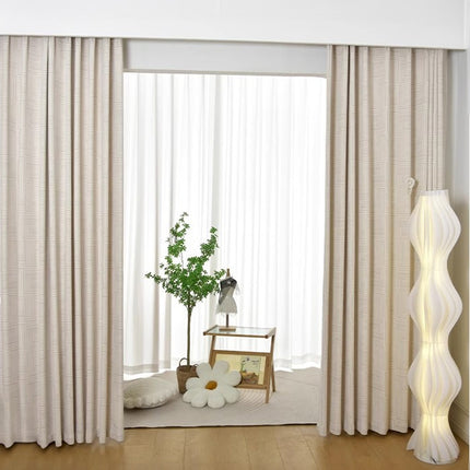 a living room with a large window and a plant in the corner