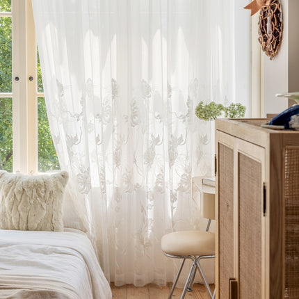 a bedroom with a bed, dresser and window