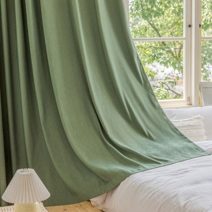 a bedroom with a green drapes and a white bed