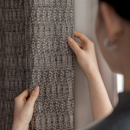 a woman is placing a piece of carpet on a wall