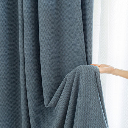 a person is opening a curtain with their hand