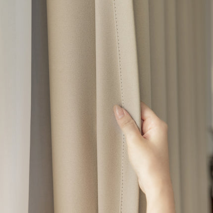 a person's hand on the curtain of a window