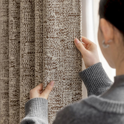 a woman is looking at a curtain in front of a window