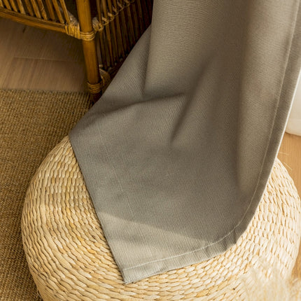 a person standing on a rug next to a wicker chair