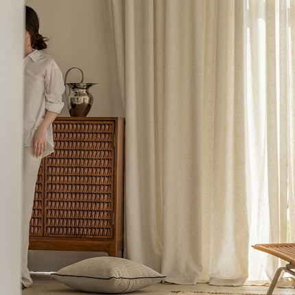 a woman standing next to a window in a room