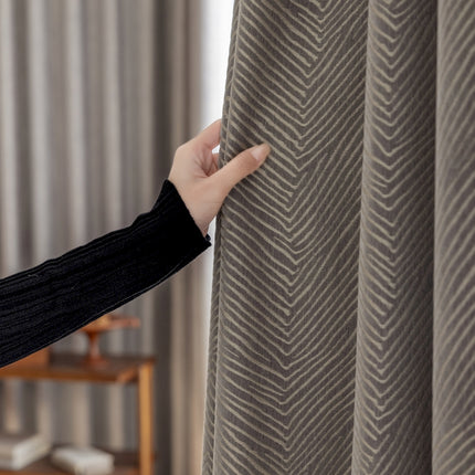 a woman is opening a curtain with her hand
