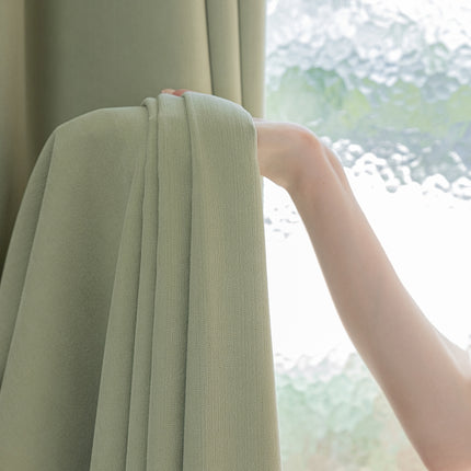 a woman's hand is holding a curtain close to a window