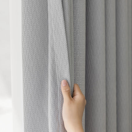 a hand that is holding a curtain in front of a window