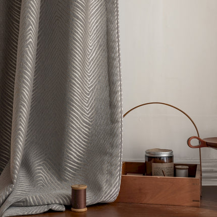 a close up of a curtain with a spool of thread next to it