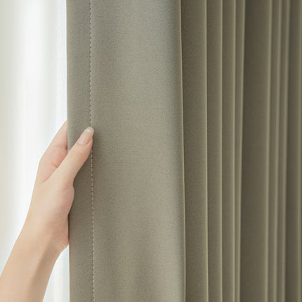 a person's hand on the curtain of a window