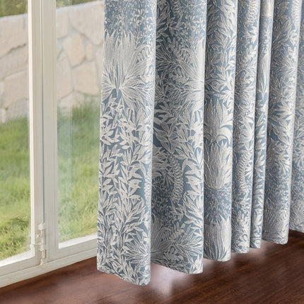 a window with a blue and white curtain hanging from it's side