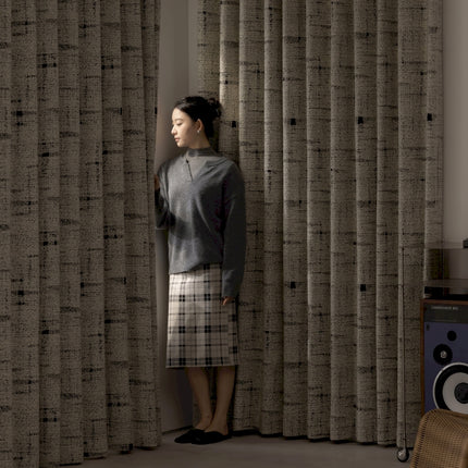 a woman standing in front of a curtain
