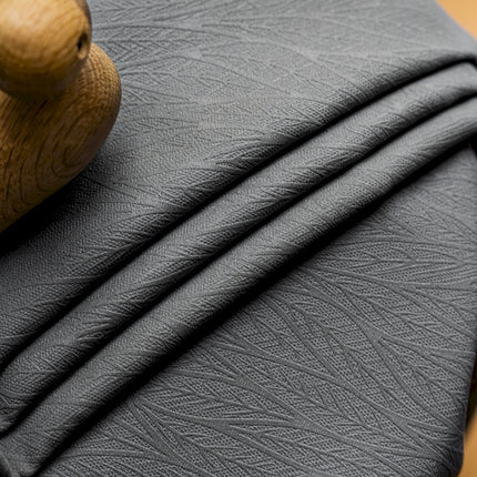 a close up of a black leather material with a wooden handle