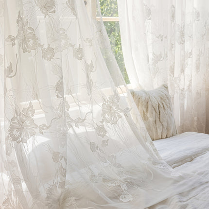 a bed with a white comforter and white curtains