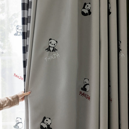 a person standing next to a curtain with panda stickers on it