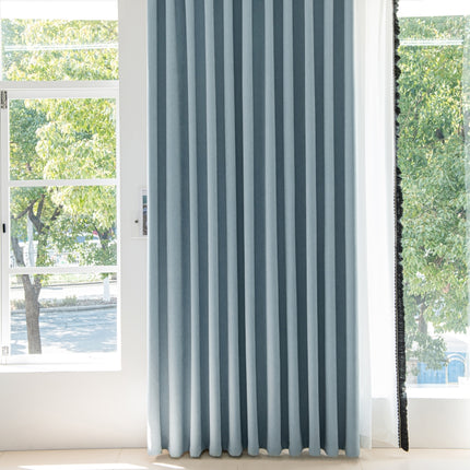 a blue curtain hanging in front of a window