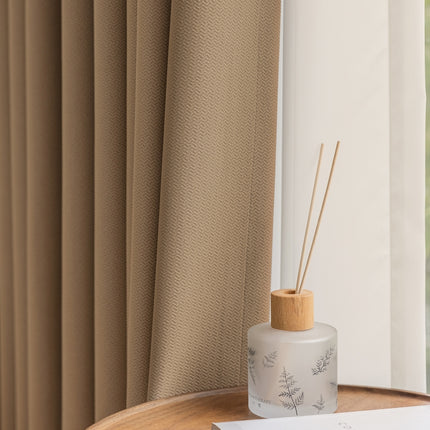 a bottle of reeds sitting on a table next to a window