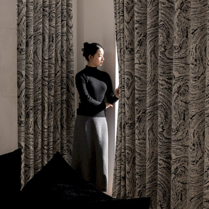 a woman standing in front of a curtain