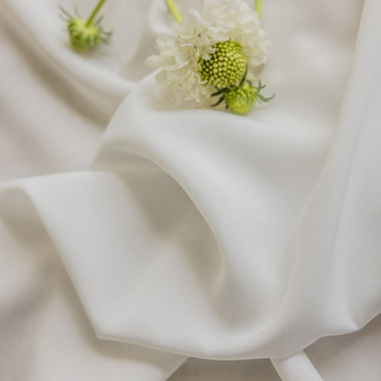 a close up of a flower on a white cloth