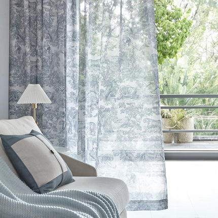 a white couch sitting next to a window covered in curtains