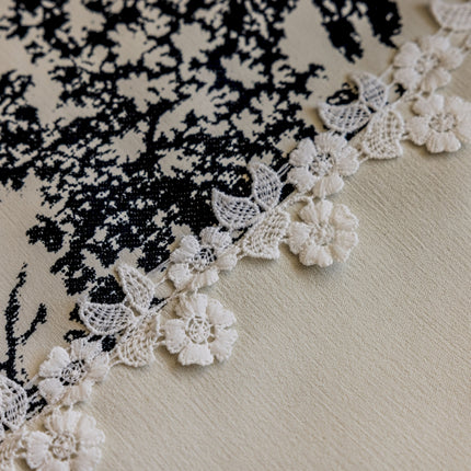 a close up of a piece of cloth with crocheted flowers on it