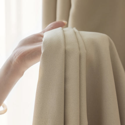 a person holding a curtain with their hand